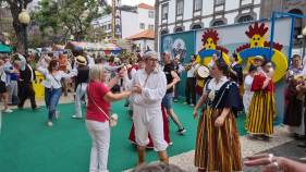Turistas cantam e bailam na placa central. Espreite o v&iacute;deo.